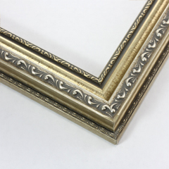This highly detailed, solid wood frame features three distinct designs.  The dominant design tops a deep scoop of smooth, brushed silver foil and meets a small detail on the inner lip.  A drop ledge on the outer edge is decorated in a simple dash.  Matte areas within the designs create an antiqued look.

2 " width: ideal for medium- to large-size images. The detailed nature of this frame makes it suitable for bright or busy paintings or photographs.  It may overpower simpler images.