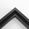 This simplistic yet modular matte black frame is designed for metal prints, acrylic prints and dry mounts. This smart design features a minimalist stepped profile that serves as a floater frame or a standard picture frame.

For the floating effect, the print can be attached on top of the inner step of the frame, without sacrificing the artwork edges.

This frame can also be used as standard picture frame. The lowered center paired with slightly raised outer lip creates a frame within a frame effect. However, due to the inner most lip of the frame, a fraction of the artwork will be hidden. But, this can be avoided with a linen liner combo.